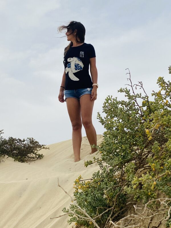 jovem com amor está na t-shirt do mar sobre a areia